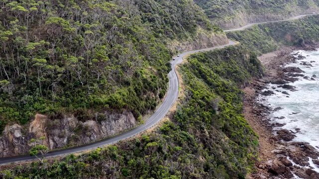 Aerial zoom in to Great Ocean road scenic cliffside drive in Victoria of Australia.