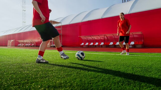 Women's soccer training session on bright green field with red uniforms, focused warmup drills, teamwork, ball control practice and dynamic athletic movement