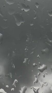Raindrops Rolling Down Glass with Blurred Background