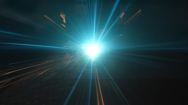 Striking close-up of bright sparks flying from heavy industrial equipment during a metalworking process. The image captures the intense heat and dynamic energy of modern manufacturing