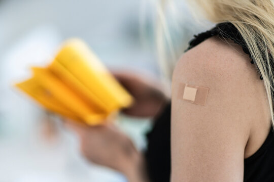 Woman with bandage on arm at vaccination center
