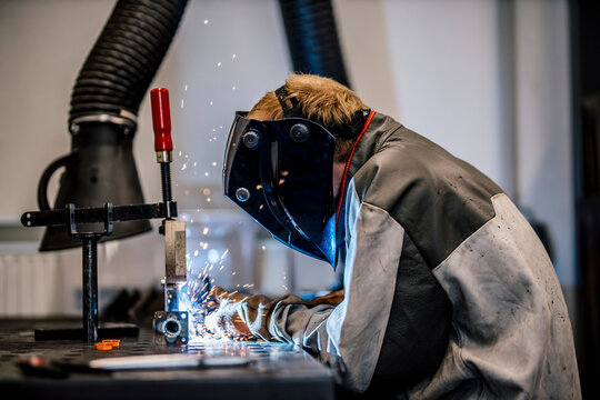 Welder with coveralls working at factory
