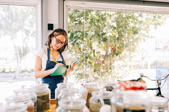 Entrepreneur writing in notebook at zero waste grocery store