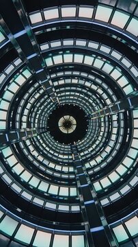 Vertical video: Pulling camera revealing skylight in circular shaft of building, highlighting ribs