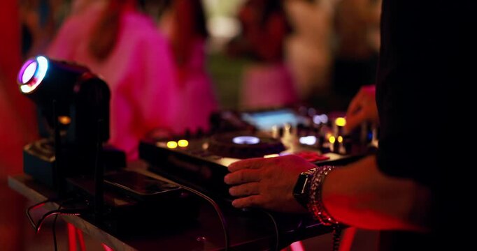 DJ playing music during summer holiday party outdoor disco club - Entertainment and vacation night life concept - Soft focus on disc jockey hand - UGC content