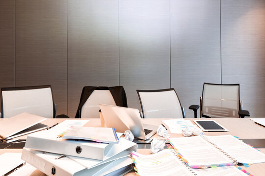 Messy documents cover the empty meeting room table in a Warsaw hotel