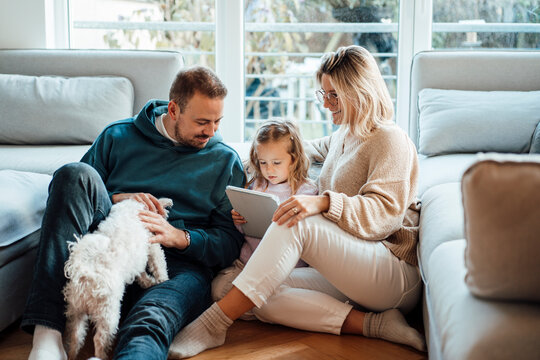 Family sitting with tablet PC in living room