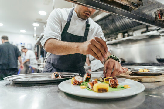 Chef garnishing plate with food