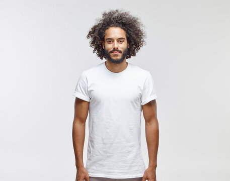 Portrait of bearded young man with curly brown hair wearing white t-shirt