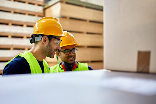 Two workers talking in factory warehouse