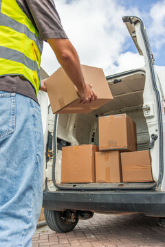 vertical Delivery driver unloading boxes from transport van for last-mile logistics