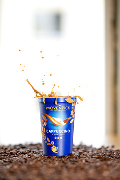 M&ouml;venpick Cappuccino iced coffee with dynamic coffee splash over roasted coffee beans &ndash; editoria
