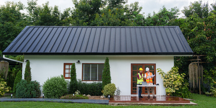 Modern residential house exterior with construction engineers working on deck