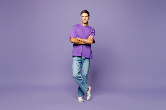 Full body young smiling happy Caucasian man wear violet t-shirt casual clothes hold hands crossed folded look camera isolated on plain pastel light purple background studio portrait Lifestyle concept