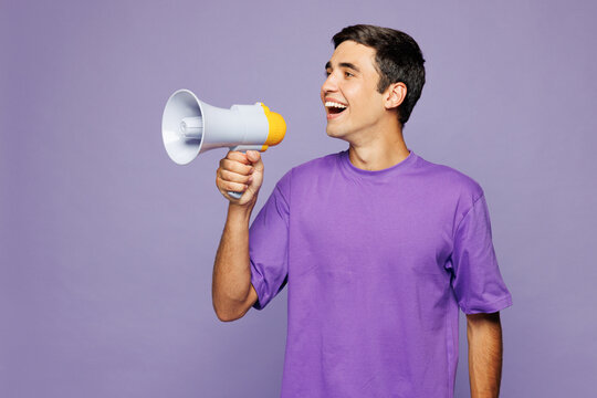 Young Caucasian man he wears violet t-shirt casual clothes hold in hand megaphone scream announces discounts sale Hurry up isolated on plain pastel light purple background studio. Lifestyle concept.