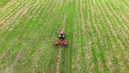 Obraz premium Tractor cultivating green field using a rotary tiller for soil preparation and farming tasks