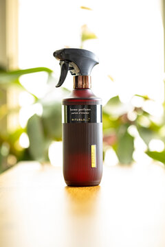 Rituals home perfume spray bottle on wooden table with blurred indoor plants background &ndash; editoria