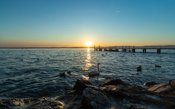 sirmione, lake garda, lombardy, italy, waterfront, lakeshore, pier, sunset, sunrise, calm water, reflection, scenic landscape, travel, tourism, europe