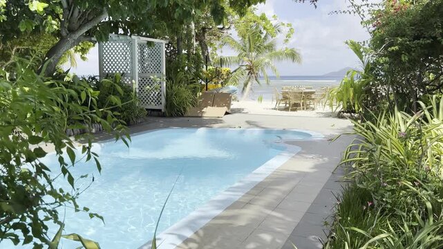 Swimming pool by private beach of secluded resort of La Digue, Seychelles