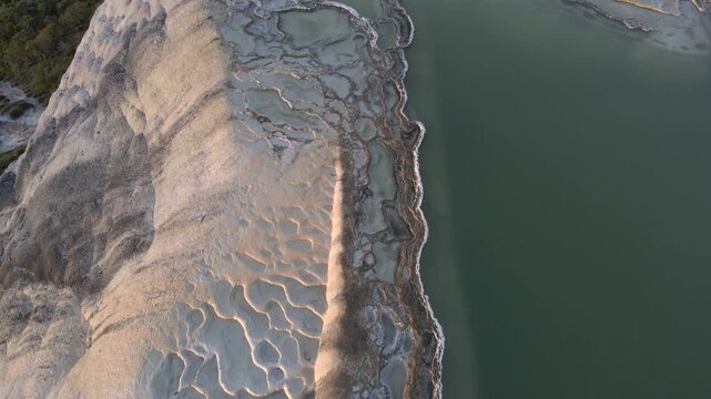 Aerial top down view of mineral pools and petrified waterfalls at Hierve el Agua, Oaxaca, Mexico. High angle drone shot of natural infinity pools and limestone rock formations during sunset.