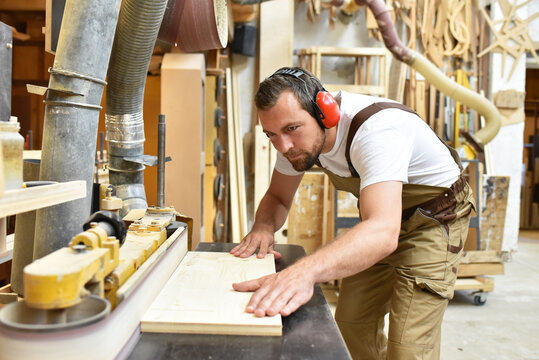 carpenter works in a joinery - workshop for woodworking and sawing