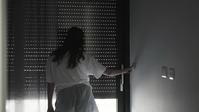 Young woman after waking up opens automatic smart home blinds using home system for comfort morning innovative technology convenience and sleep quality care relaxed modern lifestyle smart home living