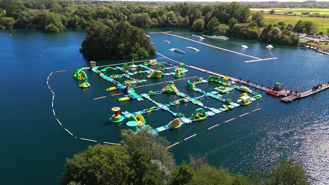 The New Forest Water Park, located near Fordingbridge in Hampshire, England, features one of the UK's first and largest outdoor floating inflatable aqua parks set on a scenic freshwater lake.