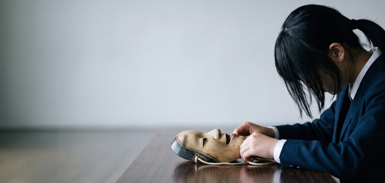 Contemplative Student Holding a Traditional Noh Mask, Identity and Inner Emotion Concept