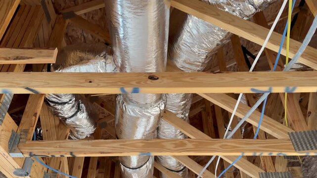 Inside of a new home after installation of the ductwork and electrical wiring, highlighting high-quality craftsmanship. Perfect for subcontractor inspection and property development projects.