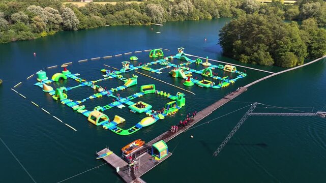 The New Forest Water Park, located near Fordingbridge in Hampshire, England, features one of the UK's first and largest outdoor floating inflatable aqua parks set on a scenic freshwater lake.