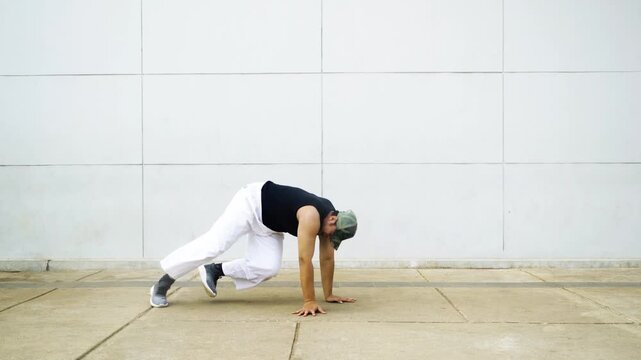 Male Breakdancer Performing Acrobatic Urban Street Dance Routines Outdoors