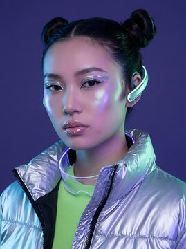 Futuristic Portrait of Young Woman with Iridescent Cyberpunk Makeup and Metallic Outerwear
