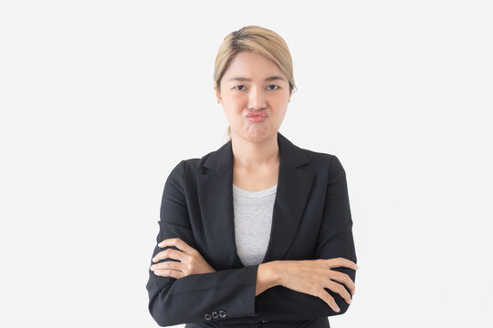 Portrait of a displeased young Asian Thai businesswoman pouting with arms crossed on white background.