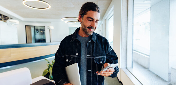 Man typing on his phone in the office