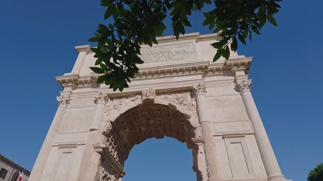 Low Angle View of the Arch of Titus Framed by Tree Branches in Rome, Italy