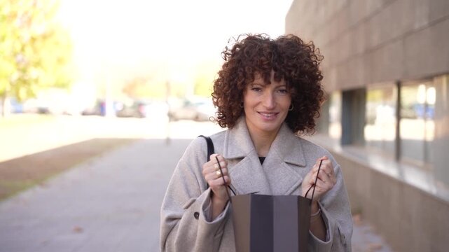 A Young Woman with Beautiful Curly Hair Captured in a Vibrant Urban Setting During Daytime