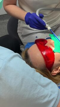 woman in dentistry tooth filling injection anesthesia. modern dental treatment with local anesthesia rubber dam filling procedure suction and bite check during professional tooth restoration