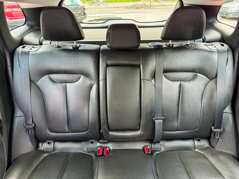 Backseat of a car shows a spacious area for passengers with leather seats without any personal items present