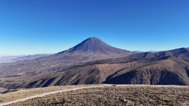 Dramatic forward aerial view flying over a cliff edge toward the majestic El Misti volcano along road 34C in the Arequipa region of Peru