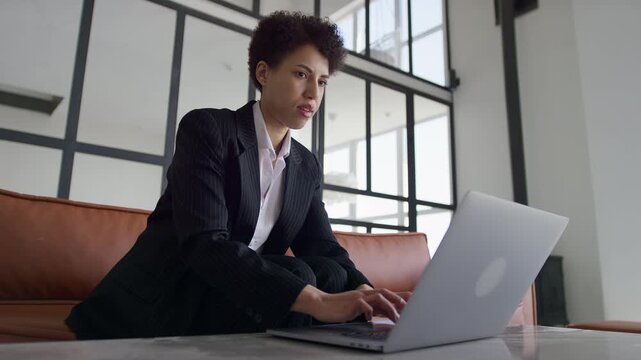Pensive Entrepreneur Working on Laptop in Office