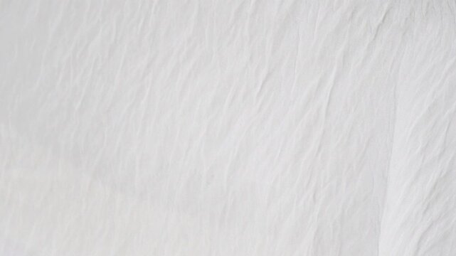 Soft white fabric background with crinkled texture waving