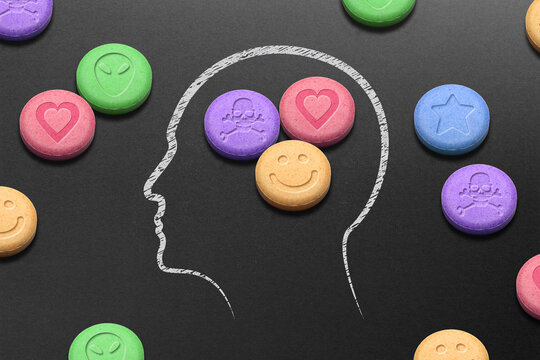 Human head silhouette filled with MDMA or Ecstasy pills on black background