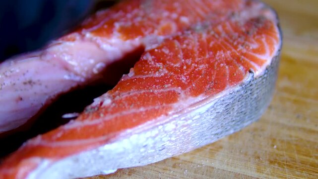 Step by step pan fried salmon steak recipe with fresh trout fillet seasoning oil and golden crust cooking process in black frying pan for homemade seafood meal
