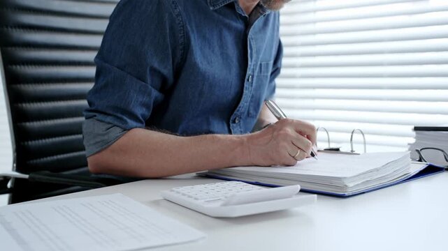 Man analyzing financial documents and calculating taxes, handling a large pile of paperwork and budgeting personal finance for business accounting or administrative tasks
