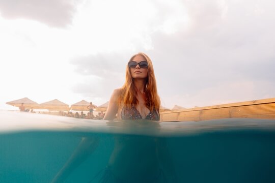 Woman relaxing in summer vacation infinity pool