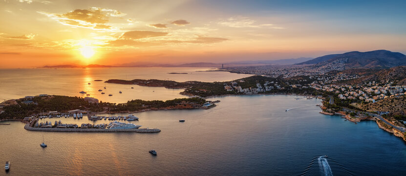 Aerial summer sunset view of the south coast of Athens, Greece, with Vouliagmeni lake, bay and beach, Laimos peninsula and famous Astir beach