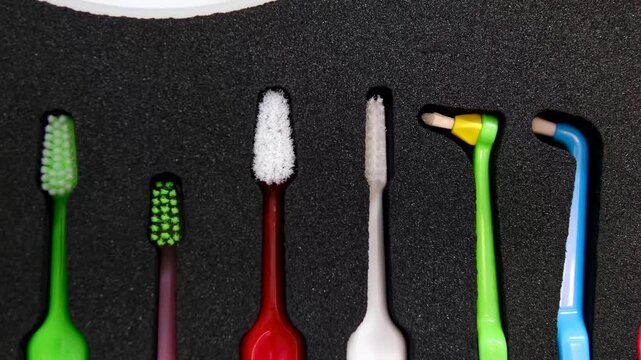 Colorful orthodontic toothbrushes arranged in row for daily oral hygiene and braces care