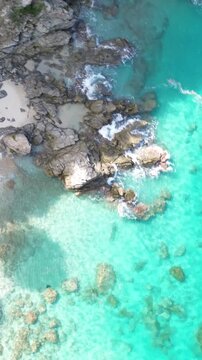 Zambrone, Costa degli Dei, Calabria, Italy. Vertical top down rotating drone footage of turquoise Tyrrhenian Sea, rocky shoreline and crystal clear water on a sunny summer day.