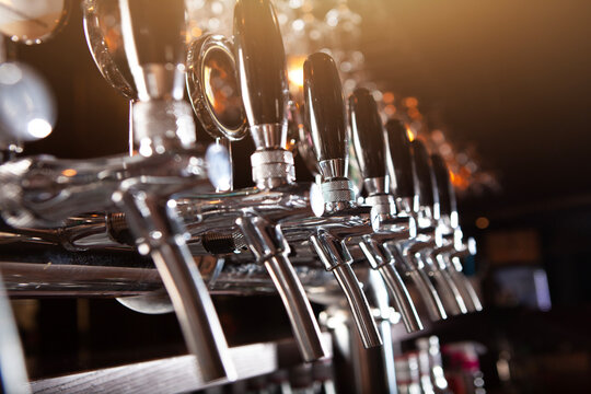 Beer bottling taps made of shiny metal. Beer taps in pub. Beer is available in bar. Concept of alcohol. Vintage style. Craft beer. Selective focus