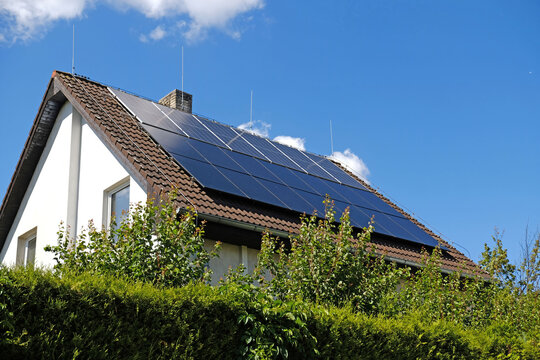 Home solar panel. Alternative energy is used for heating and water heating. Eco-friendly alternative energy for house. Residential family house suburban. Brown tile roof of home with solar panels.